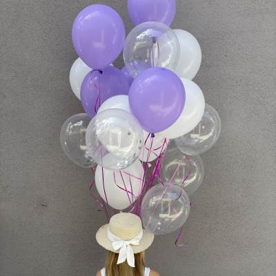Cluster of lavender, white, and clear balloons held by a girl in a straw hat