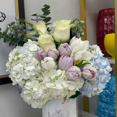 White and pastel flower arrangement in a white vase