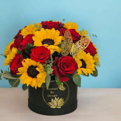 Red roses and yellow sunflowers in a black hat box