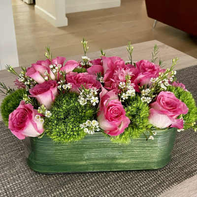 Pink roses and green moss in a rectangular green container