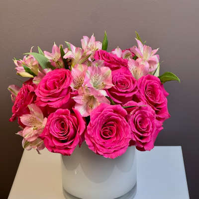 Pink roses and pale pink alstroemeria in a white vase