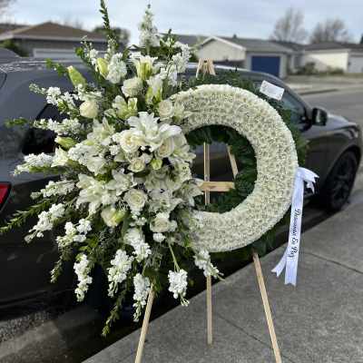 White funeral wreath and matching floral spray on easels