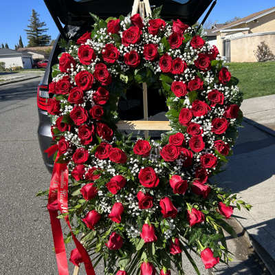 Large heart-shaped wreath of red roses on a standing easel