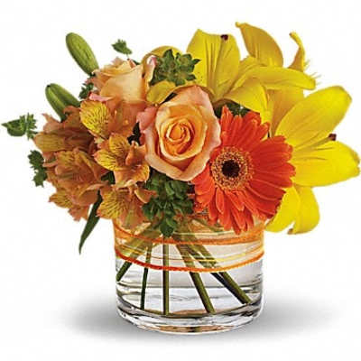 Orange roses and yellow lilies in a clear glass vase