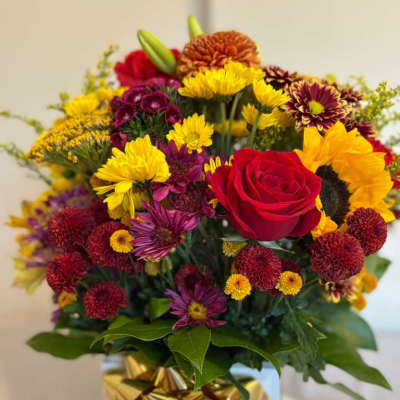 Mixed bouquet with a red rose and yellow sunflowers in a gift box