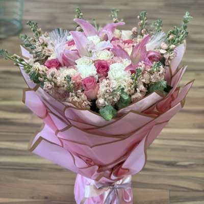 Pink bouquet with roses and lilies wrapped in pink paper