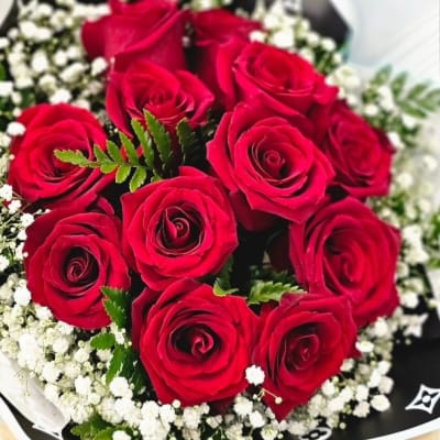 Bouquet of red roses with white baby's breath in black wrap