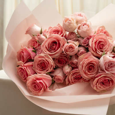 Bouquet of pink roses wrapped in pale pink paper