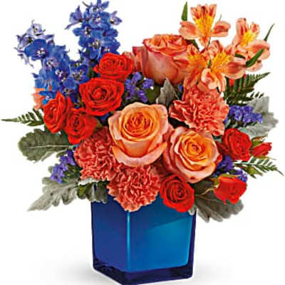 Bouquet of red and peach roses with blue flowers in a blue vase