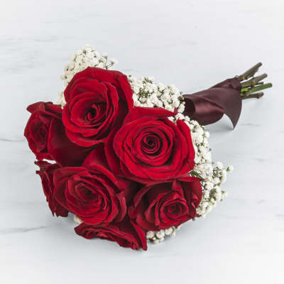 Bouquet of red roses with white baby's breath wrapped in burgundy paper