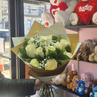 Bouquet of cream roses with baby's breath in brown and white wrap