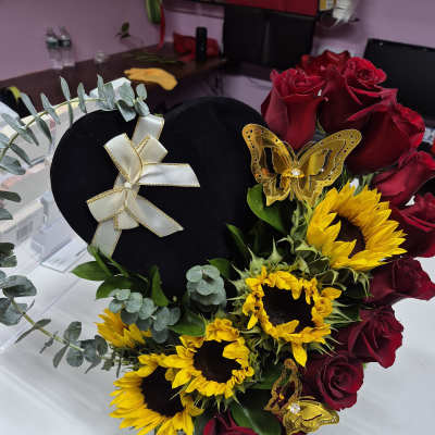 Heart-shaped floral arrangement with red roses and yellow sunflowers