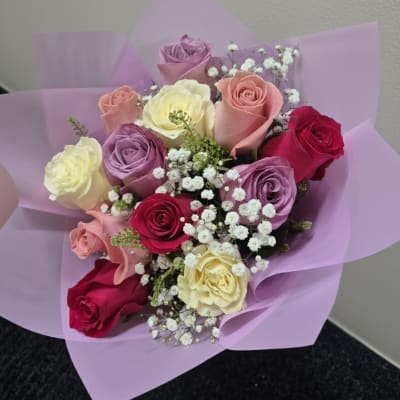 Bouquet of multicolored roses wrapped in lavender paper