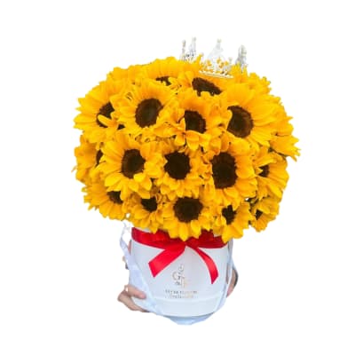 Bouquet of yellow sunflowers in a white hatbox with a red ribbon