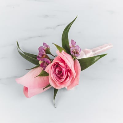 Pink rose boutonniere with purple accents and ribbon
