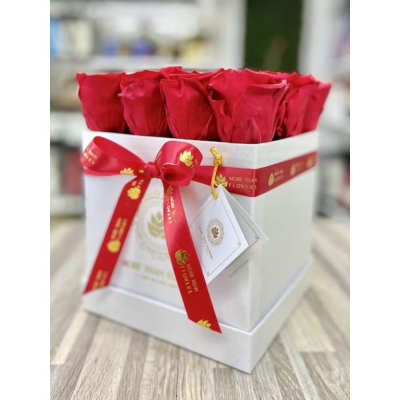 Box arrangement of red roses in a white square gift box with red ribbon and tag