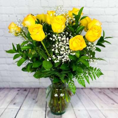 Yellow roses with baby's breath in a clear glass vase
