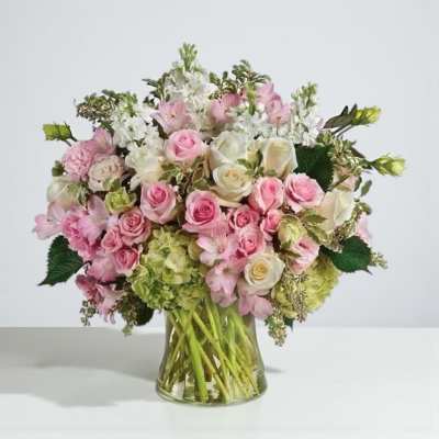 Pink and white rose bouquet in a clear glass vase