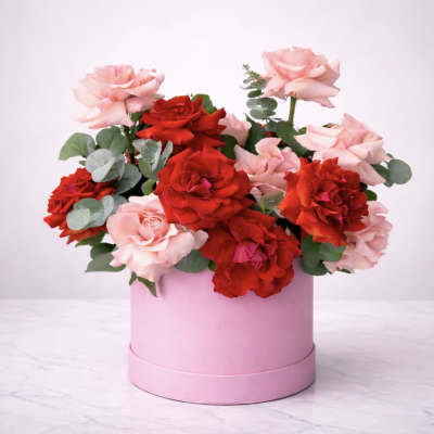 Pink and red roses arranged in a round pink box