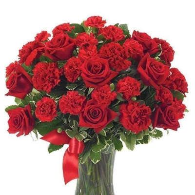 Red roses and carnations in a glass vase with a red ribbon
