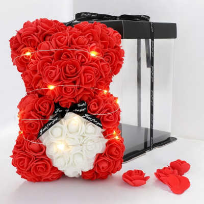 Red rose teddy bear with a white heart on a clear gift box