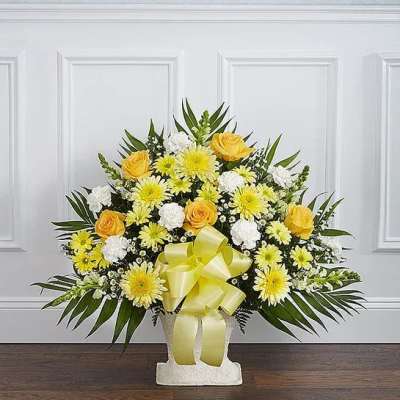 Yellow and white floral arrangement with a ribbon in a white vase