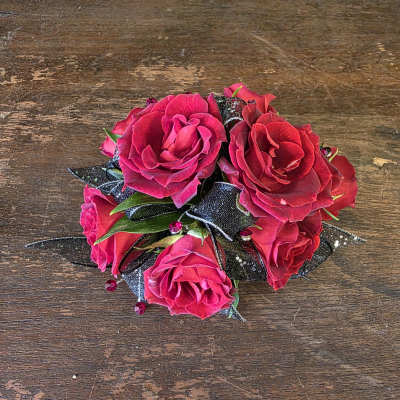 Small bouquet of bright pink roses with black ribbon accents