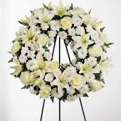 White floral wreath on a black easel stand