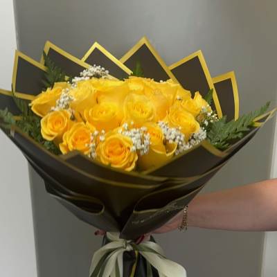 Bouquet of yellow roses with baby's breath in black and gold wrapping