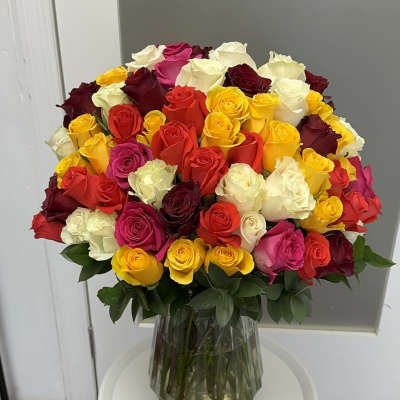 Large bouquet of multicolored roses in a clear glass vase