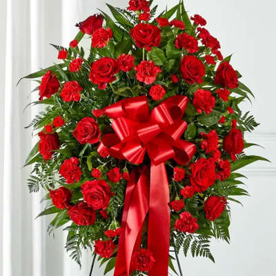 Standing wreath of red roses and carnations with a large red bow