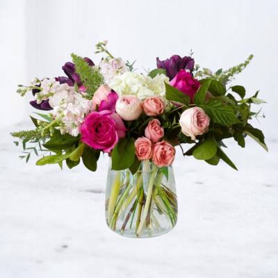 Mixed pink and white flowers in a clear glass vase