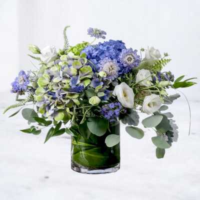 Blue and white floral arrangement in a glass vase