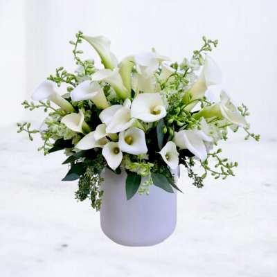 White calla lily bouquet in a pale vase