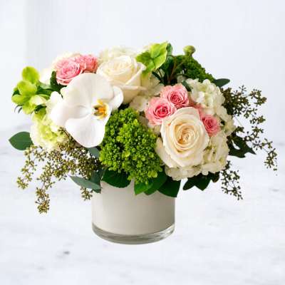 Bouquet of white and pink roses with a white orchid in a glass vase