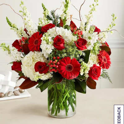 Red roses and gerbera daisies in a clear glass vase