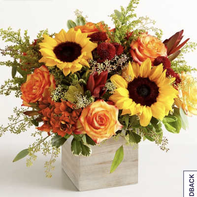Sunflower and orange rose arrangement in a wooden cube vase