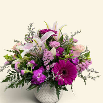 Pink and white mixed flower arrangement in a white textured vase