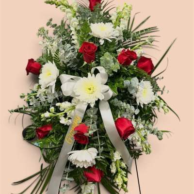 Standing floral spray with red roses and white daisies on a ribboned easel