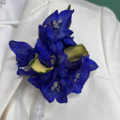 Blue flower boutonniere with white ribbon wrap