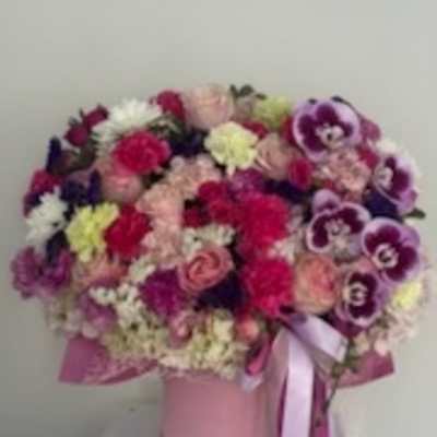 Pink and purple mixed bouquet in a pink hat box with ribbon