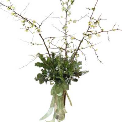 Tall branch arrangement with white blossoms in a glass vase