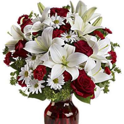 Red roses and white lilies in a red glass vase