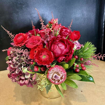 Red floral arrangement in a clear glass vase with pink accents