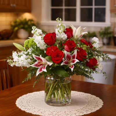 Red roses and white lilies arranged in a clear glass vase