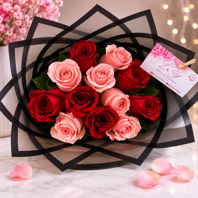 Bouquet of red and pink roses wrapped in black paper