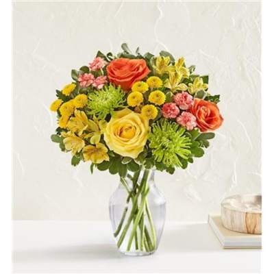 Bouquet of orange and yellow roses in a clear glass vase
