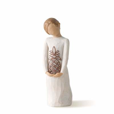 Wooden angel figurine holding a carved pineapple