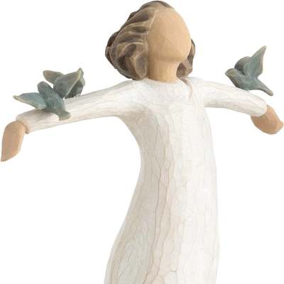 Wooden angel figurine in a white dress with outstretched arms