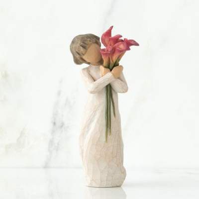 Decorative figurine holding pink calla lilies